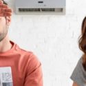 Frustrated man and woman looking at malfunctioning air conditioning unit, indicating need for AC services and repairs.