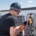 HVAC technician wearing safety gear, including a hard hat and gloves, working on air conditioning unit on a rooftop, representing safety and professionalism in home service.
