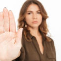Woman with raised hand signaling stop, emphasizing the importance of preventative measures in plumbing maintenance and emergency preparedness.