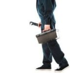 Professional plumber in dark attire with toolbox and wrench, ready for 24-hour emergency plumbing services.