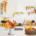 Cozy kitchen with autumn decor, fruit basket, and white cabinets, featuring tips by Carmine's Plumbing.