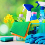 Cleaning supplies including spray bottles, sponges, and gloves, emphasizing home maintenance for improved air quality and HVAC efficiency.