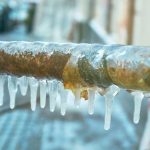 Frozen pipe with icicles, illustrating the risks of unprotected outdoor plumbing during winter, relevant to winterization advice from Carmine's Plumbing, Heating & Air Conditioning.