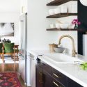 Modern kitchen with stainless steel appliances and open shelving, showcasing home comfort solutions by Carmine's Plumbing.