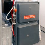 Goodman furnace unit in a residential setting, highlighting heating system maintenance and repair services by Carmine's Plumbing, Heating & Air Conditioning.