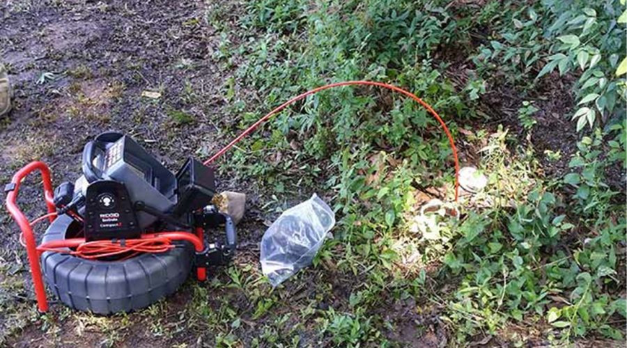 Sewer inspection camera system with cable and light in outdoor setting for plumbing maintenance by Carmine's Plumbing.
