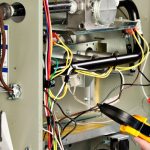 Heating system repair with visible wires and components, highlighting HVAC maintenance and repair services by Carmine's Plumbing, Heating & Air Conditioning.
