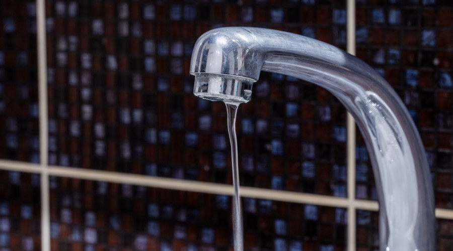 Chrome faucet pouring water